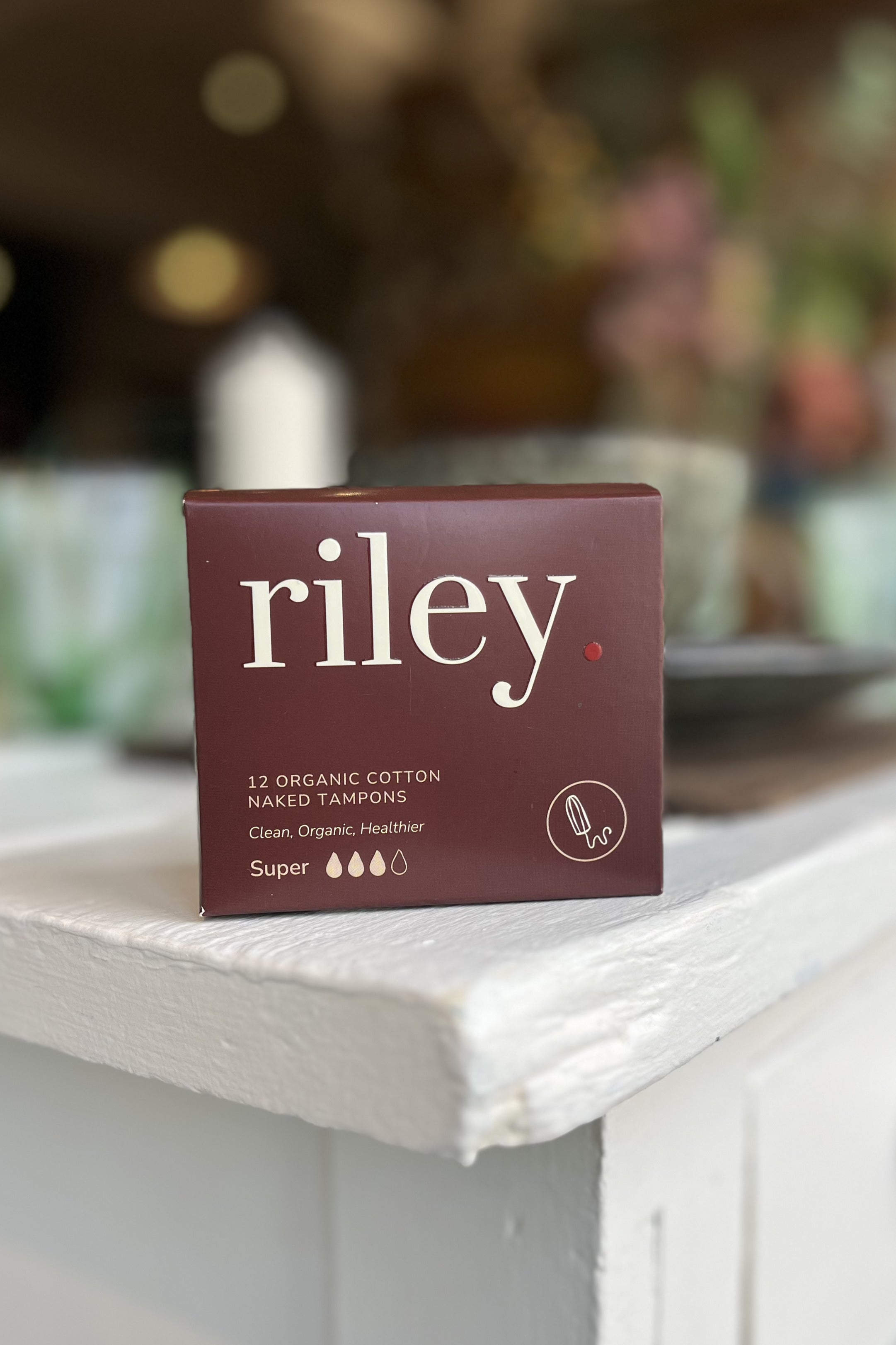 Box of Riley organic cotton tampons on a white surface with a blurred background