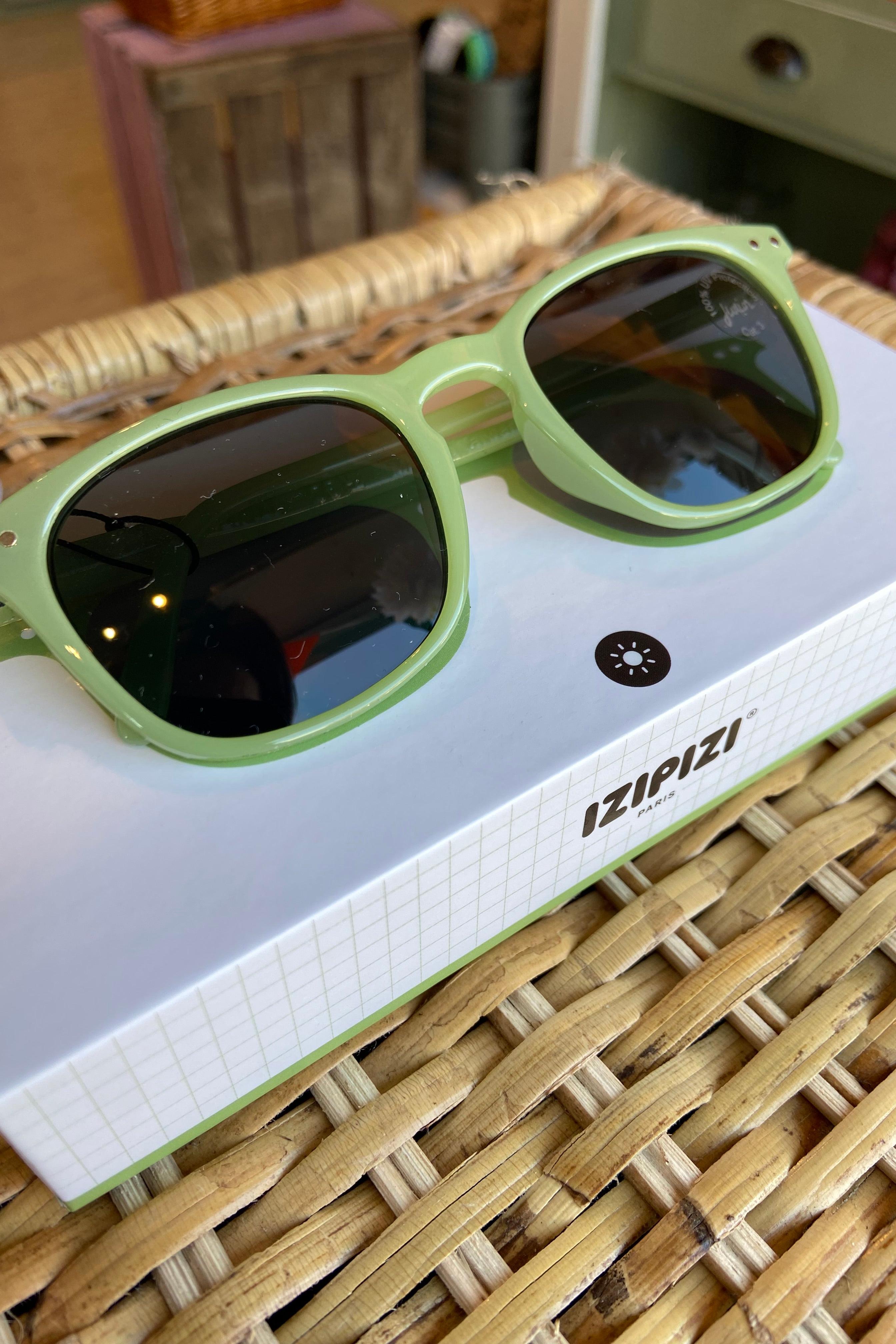 Detailed view of IZIPIZI Junior Sun #E Pear sunglasses, highlighting the soft-touch frame and 100% UV category 3 lenses.