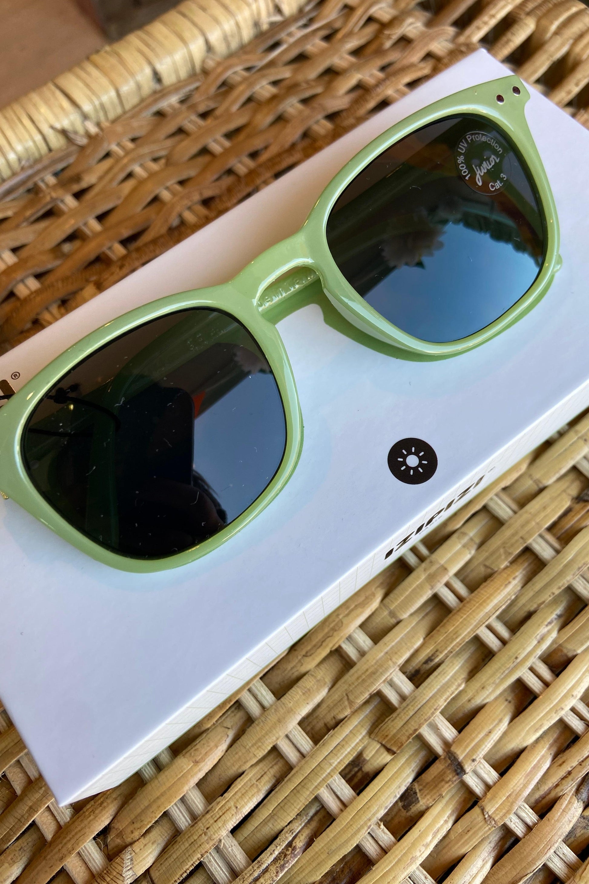 Detailed view of IZIPIZI Junior Sun #E Pear sunglasses, highlighting the soft-touch frame and 100% UV category 3 lenses.
