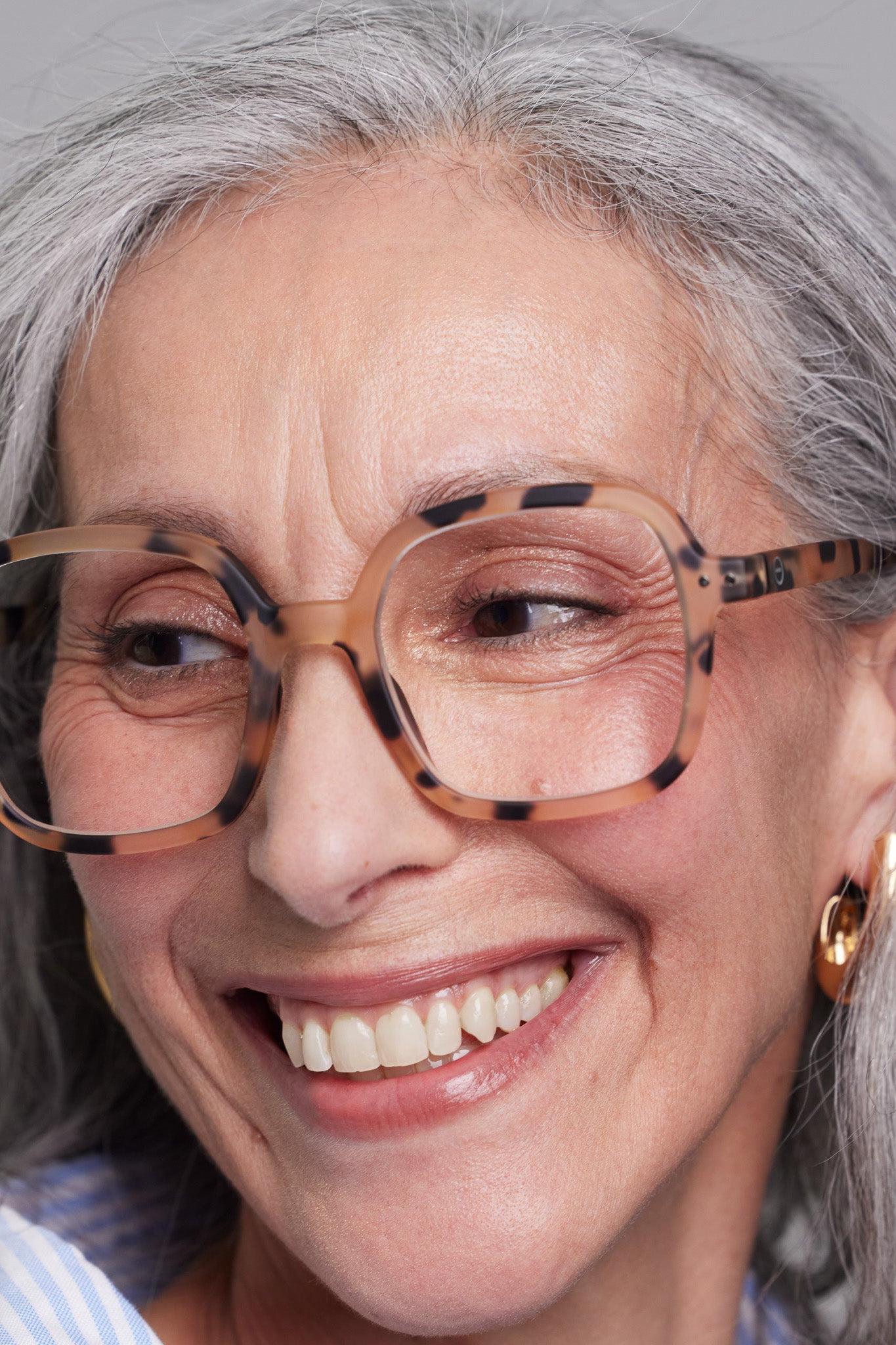 Model wearing the Izipizi Reading #OFFICE Light Tortoise glasses, showcasing their tortoise design and oversized shape.