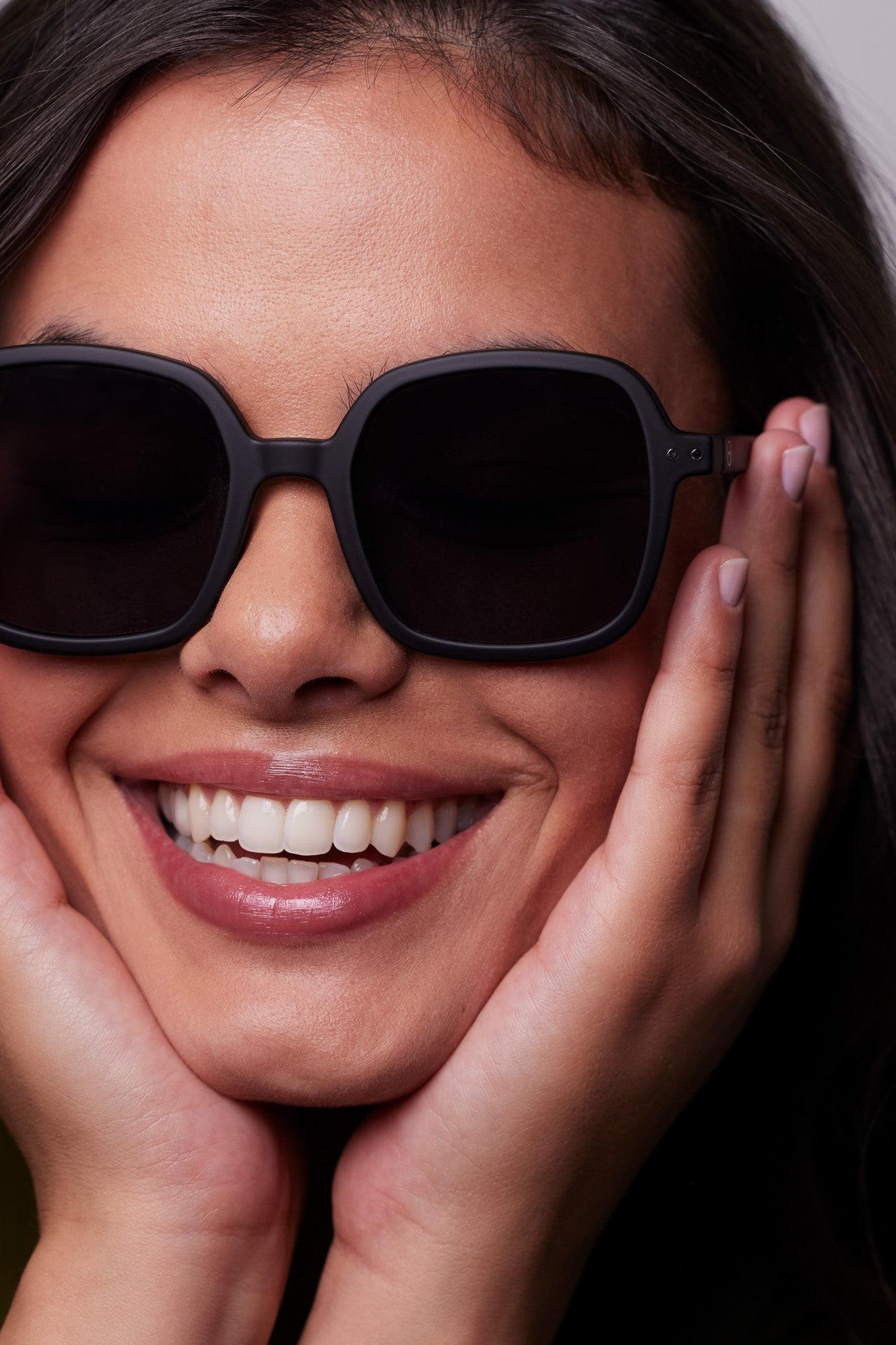 Model smiling wearing the Izipizi Sun OFFICE Black sunglasses.
