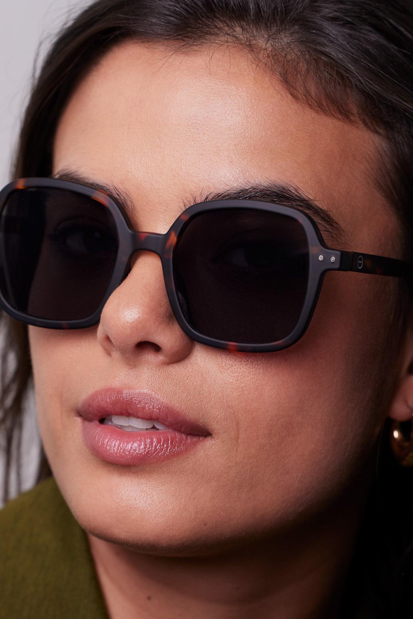 Model wearing the Izipizi Sun #OFFICE Tortoise sunglasses, highlighting oversized shape.