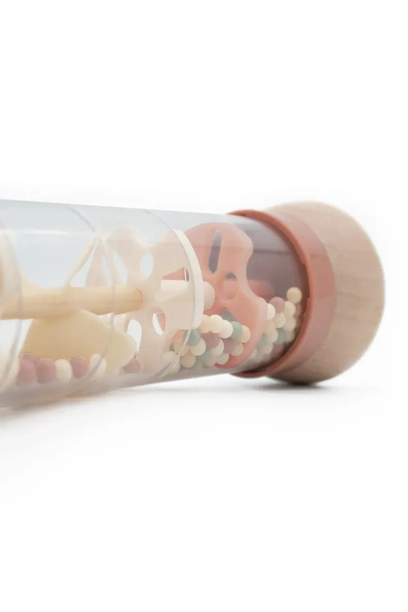 Glass tube filled with colorful beads on a white background