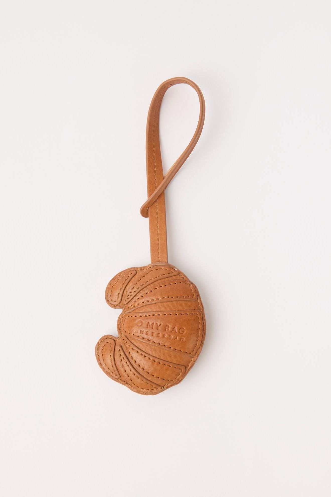 Brown leather keychain with embossed design on a white background