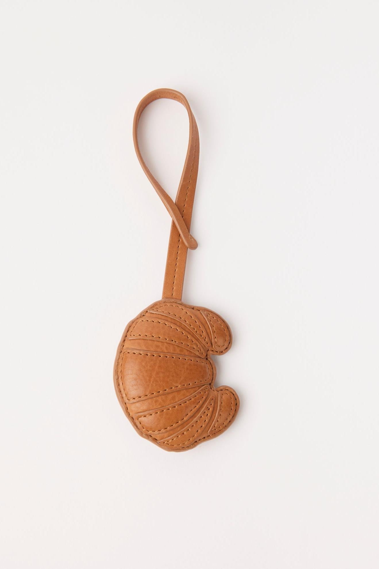 Brown leather keychain with a strap on a white background
