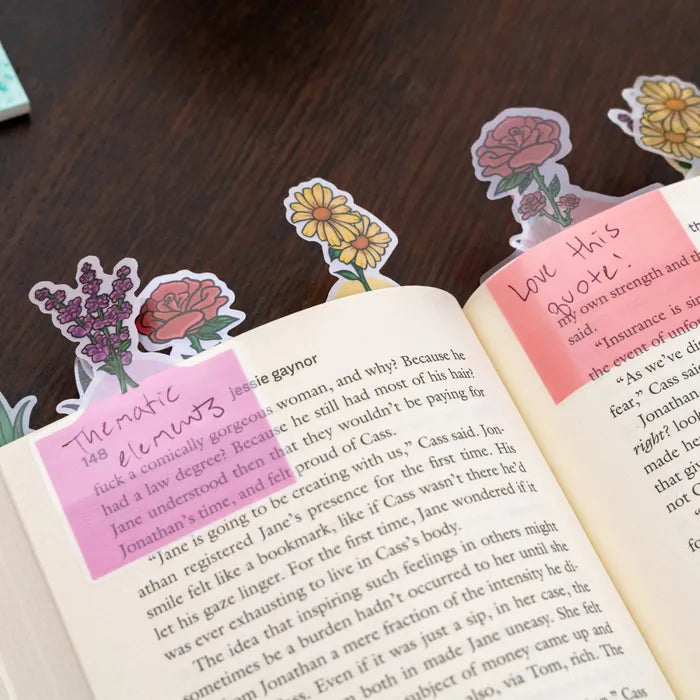 Kikkerland Annotation Garden page tabs in use, marking pages in a book with floral designs.