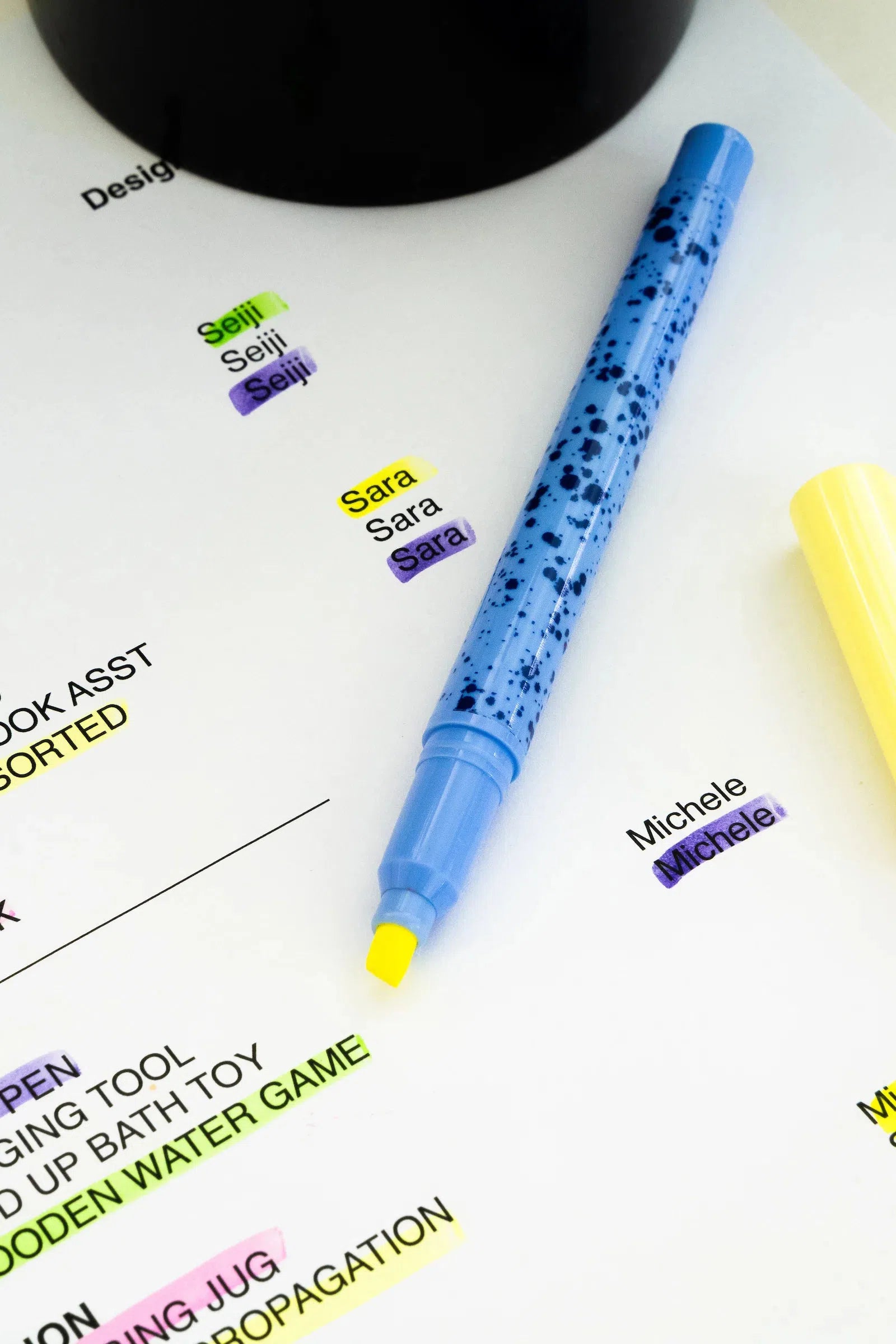 A blue erasable highlighter marking text on paper, with other colours and erased markings visible.