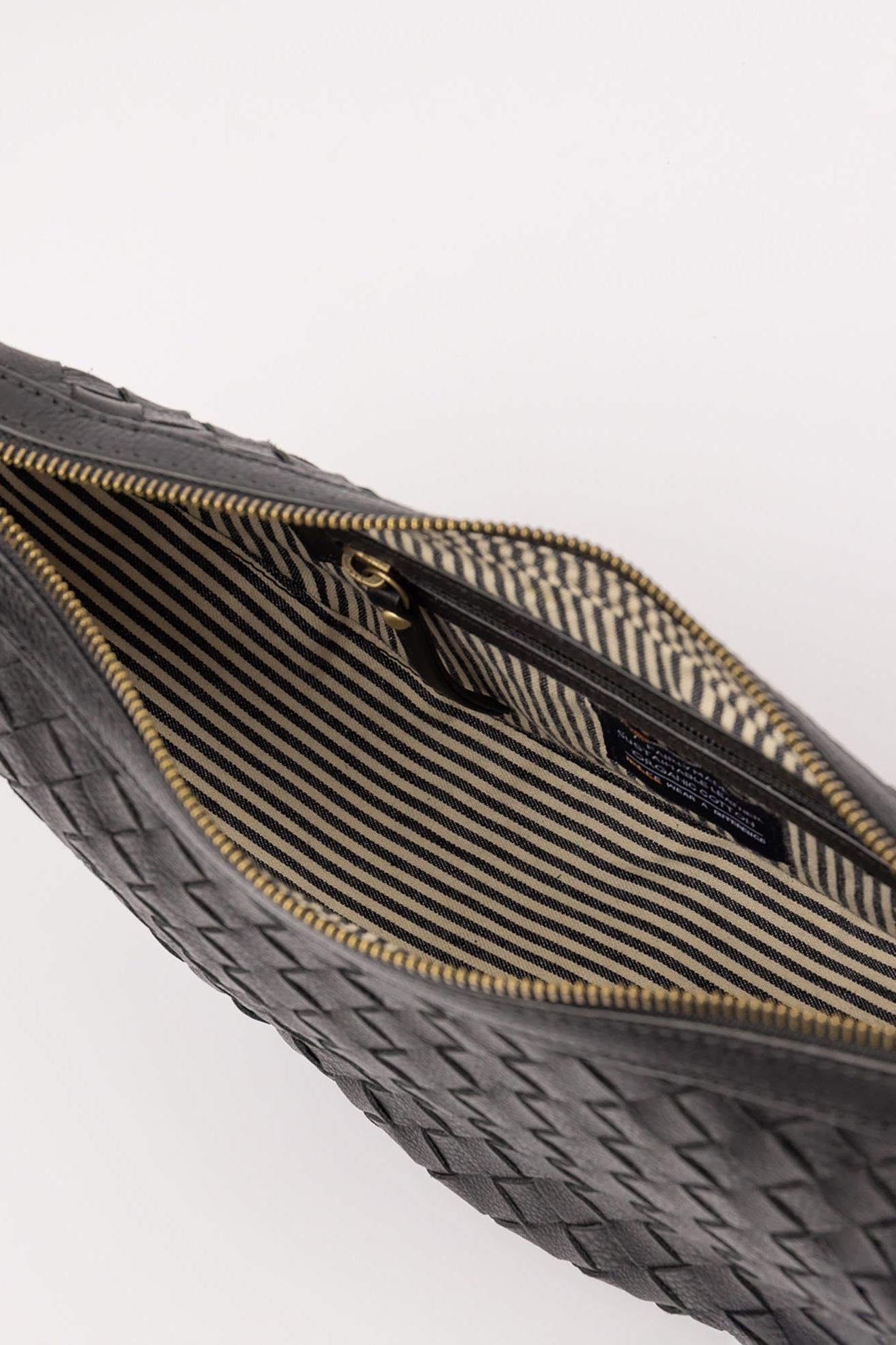 Close-up of a woven handbag and striped lining on a white background
