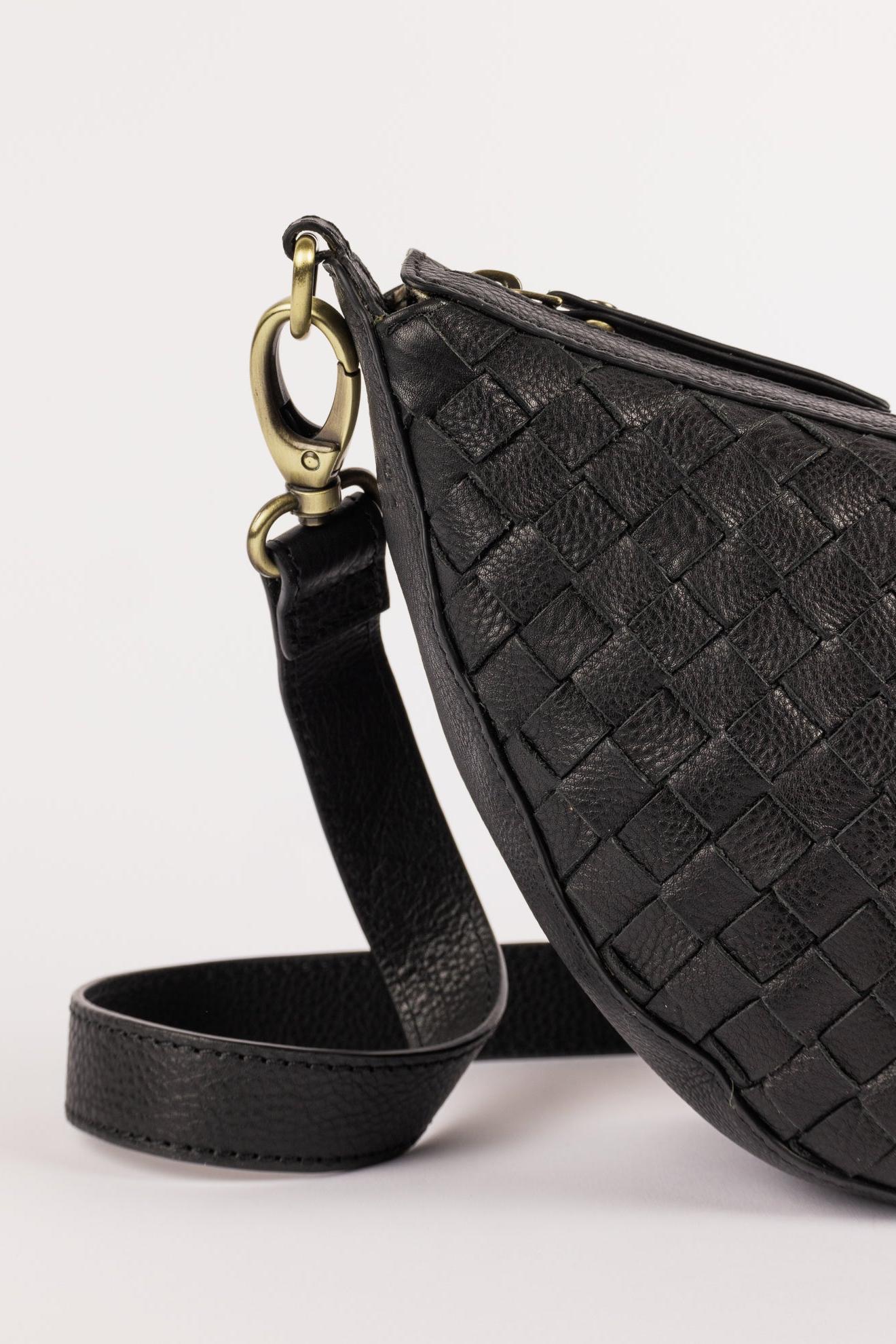 Black woven leather bag with a strap on a white background