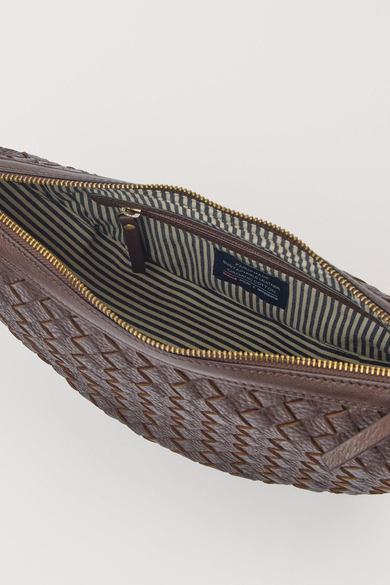 Brown woven waist bag with gold zipper on a light gray background