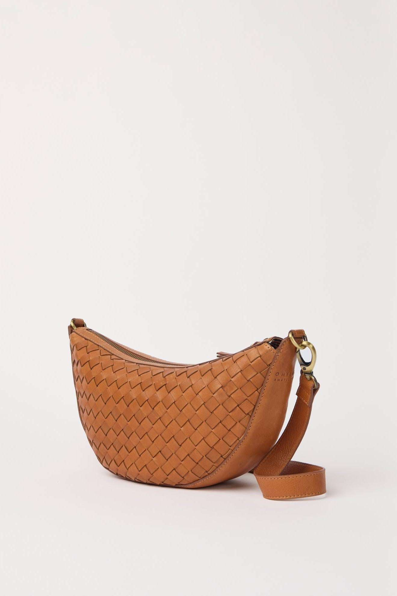 Brown woven handbag with a strap on a light beige background