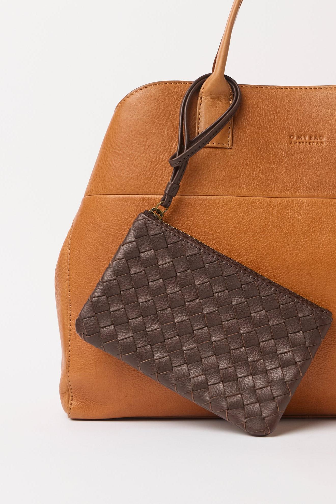 Brown leather handbag with a matching woven pouch on a white background