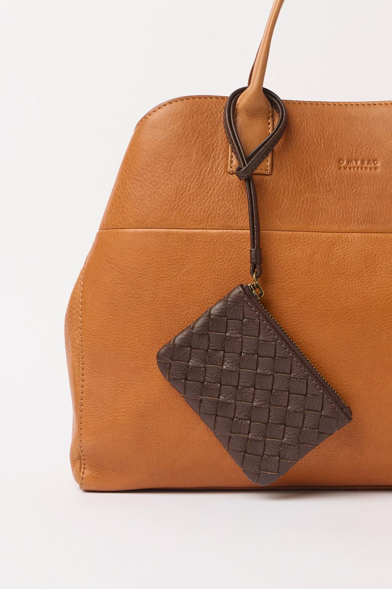 Brown leather handbag with a matching woven pouch on a white background