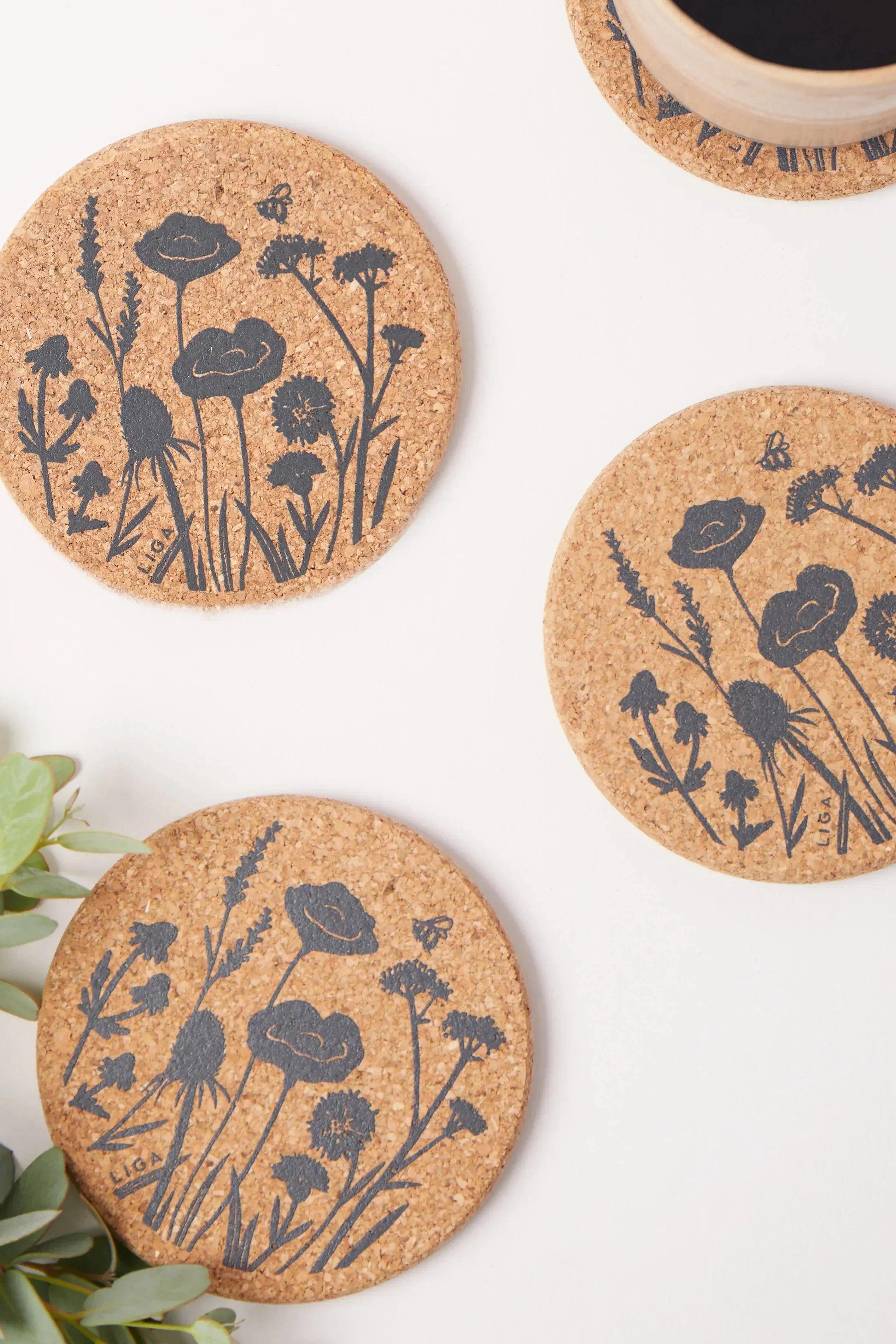 Cork coasters with floral designs on a white surface