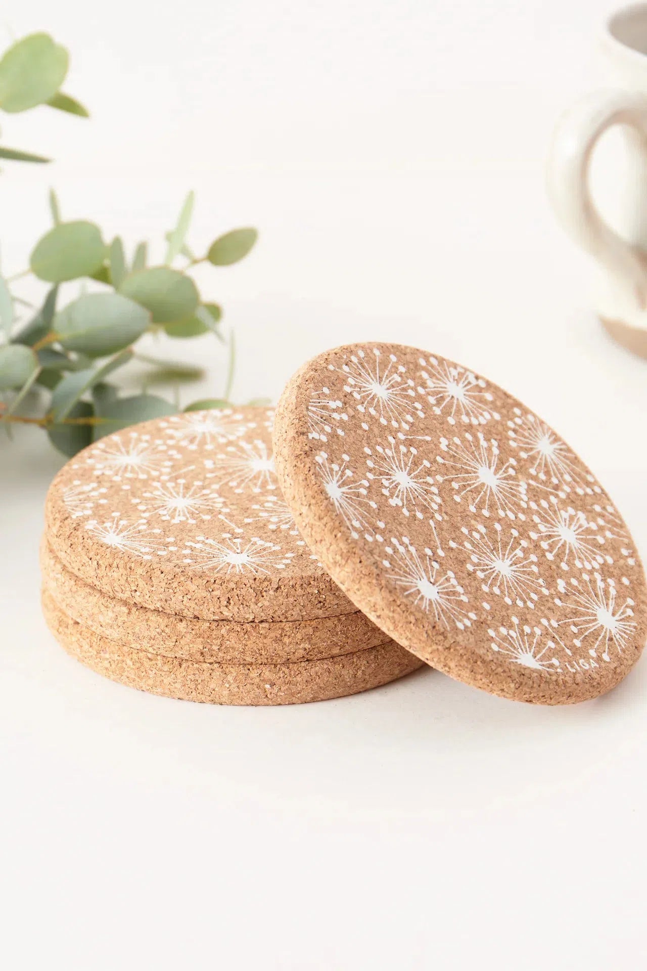 Liga Cork Coasters featuring dandelion design, placed on a table.