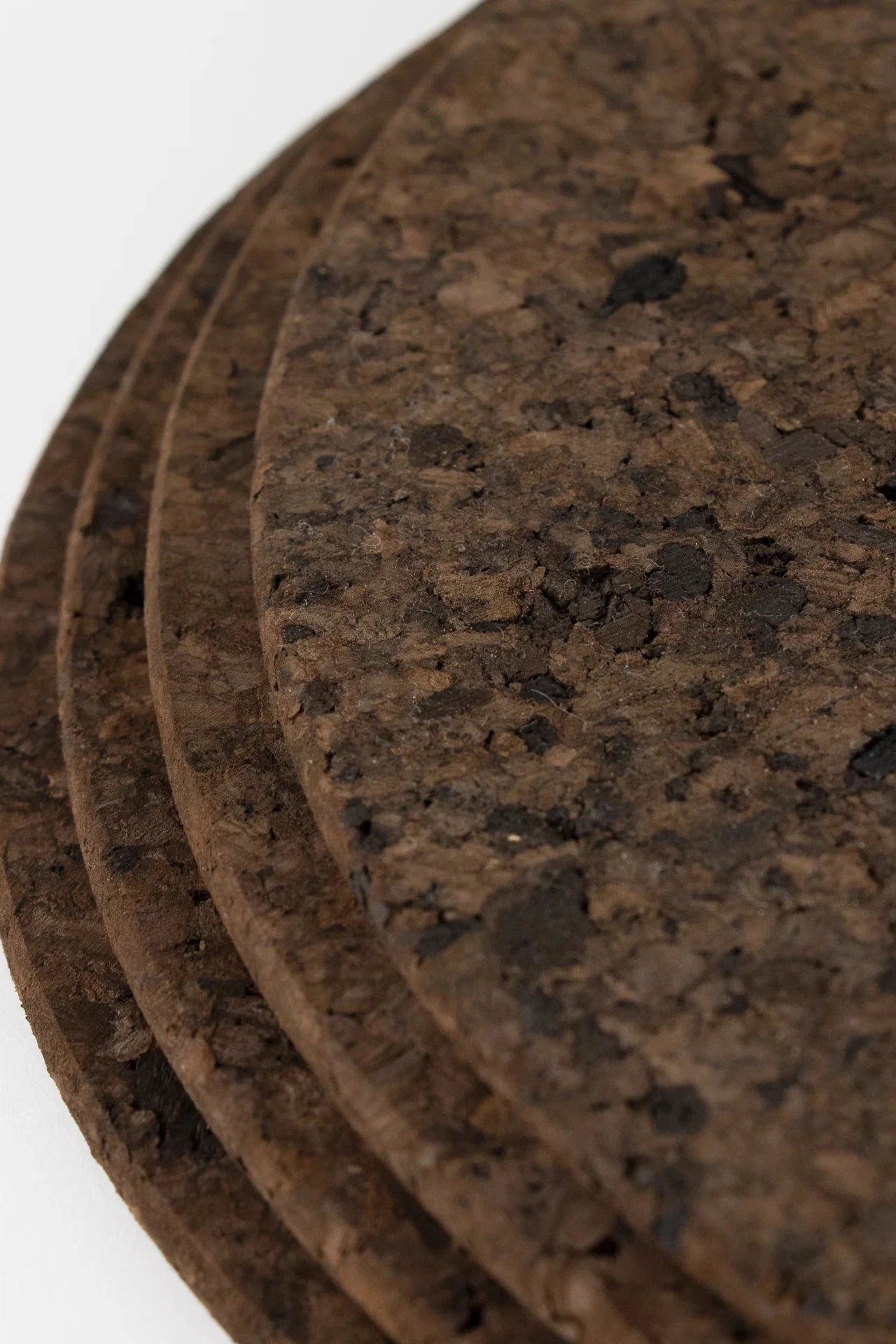 Set of Liga Smoked Cork Round Placemats with a sleek, contemporary design and a unique smoked finish.