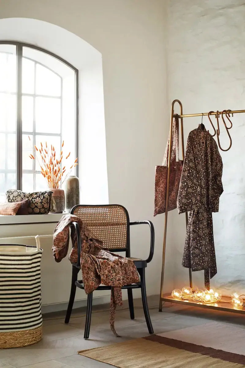Room interior with a chair, coat rack, and decorative items.