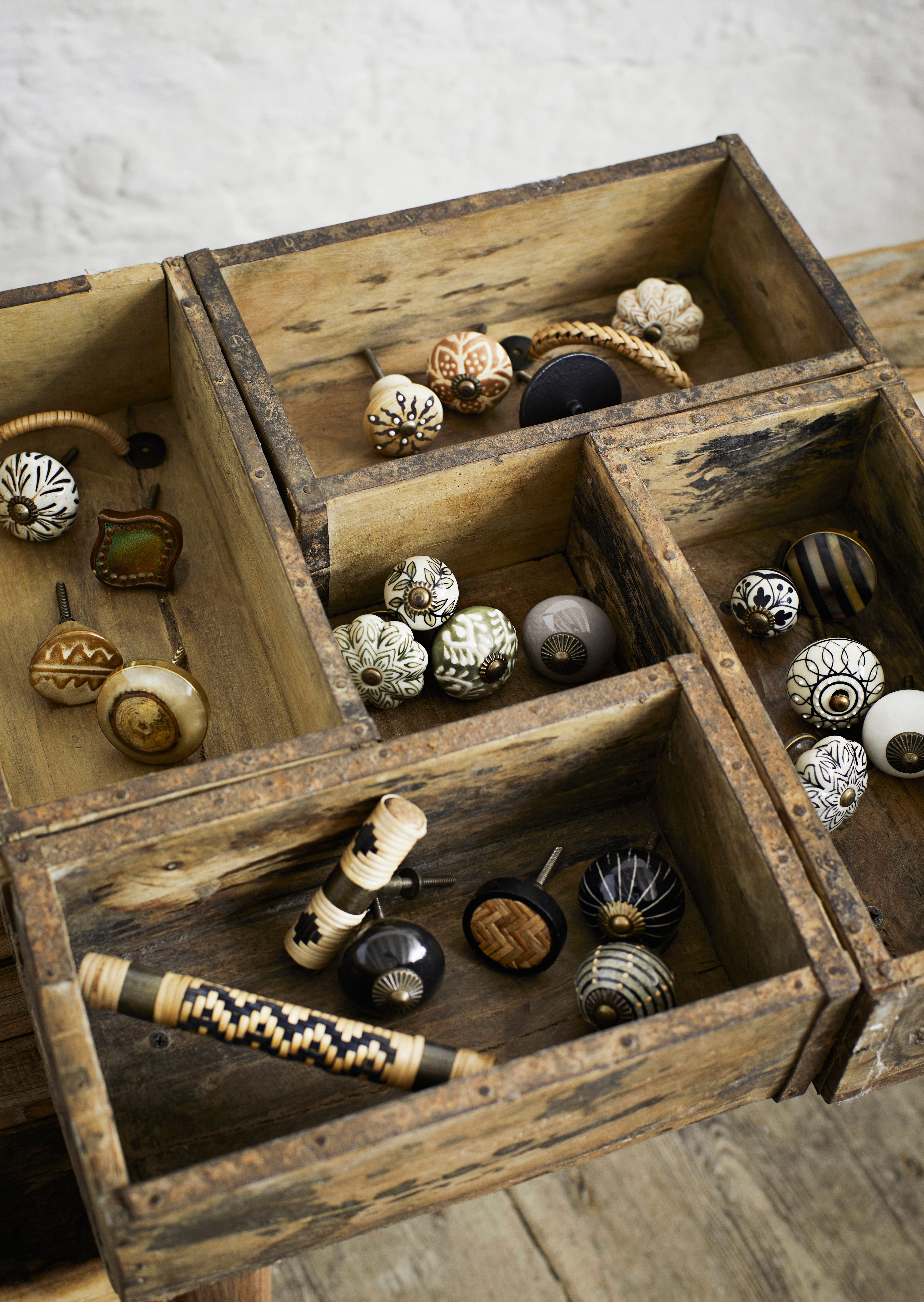 Wooden box with decorative knobs on a wooden surface