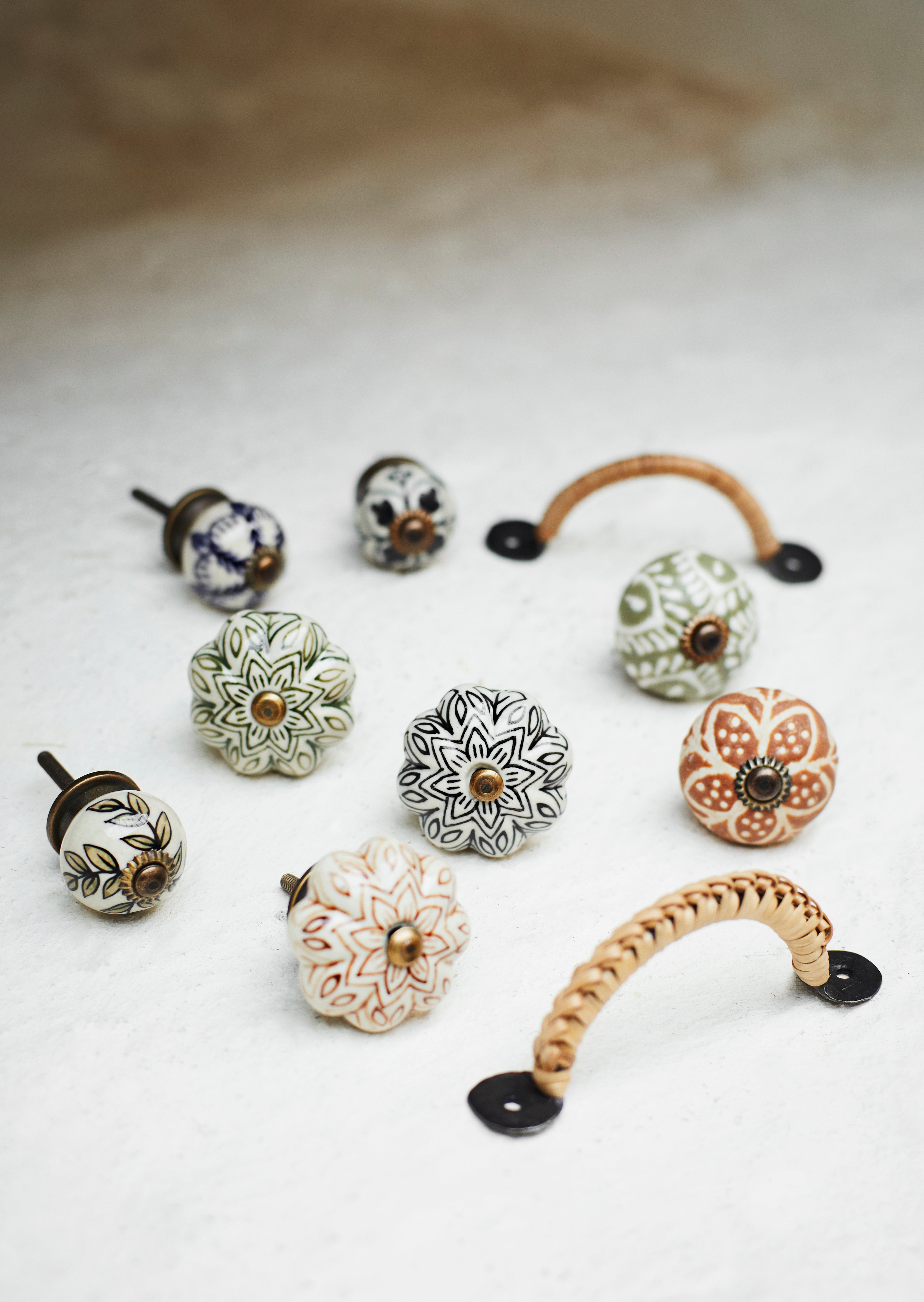 Collection of ceramic Madam Stoltz cabinet knobs and handles on a light background