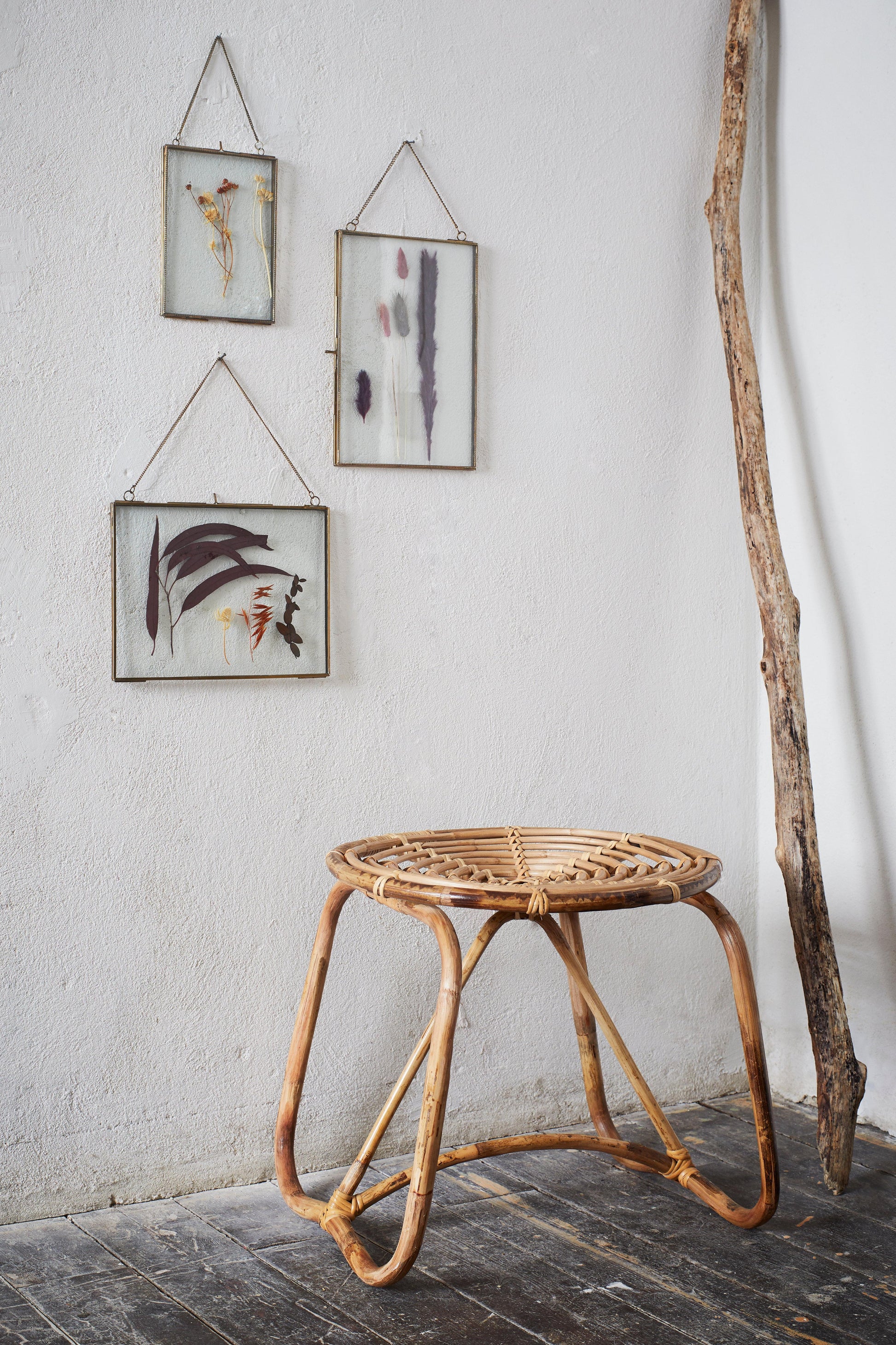 Wicker side table with framed abstract art on a white wall