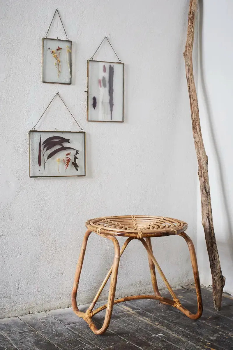 Wicker side table with framed abstract art on a white wall