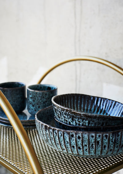 Set of blue ceramic bowls on a gold tray with a white background