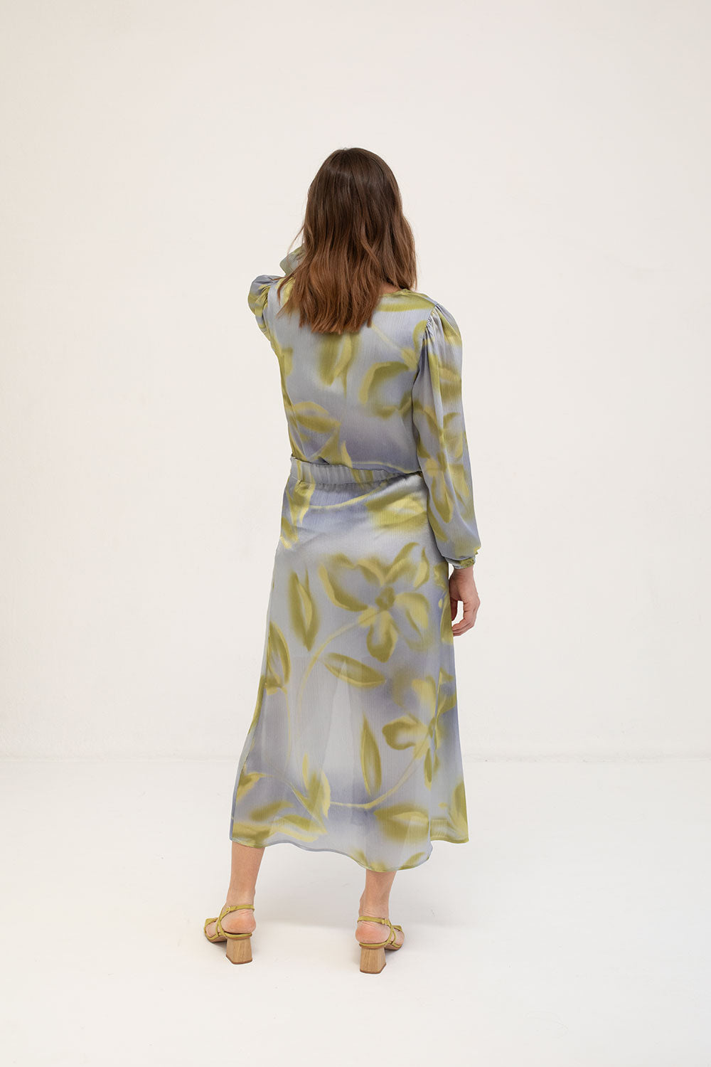 Back view of blouse featuring a satin finish with a subtly textured print paired with the same printed skirt.