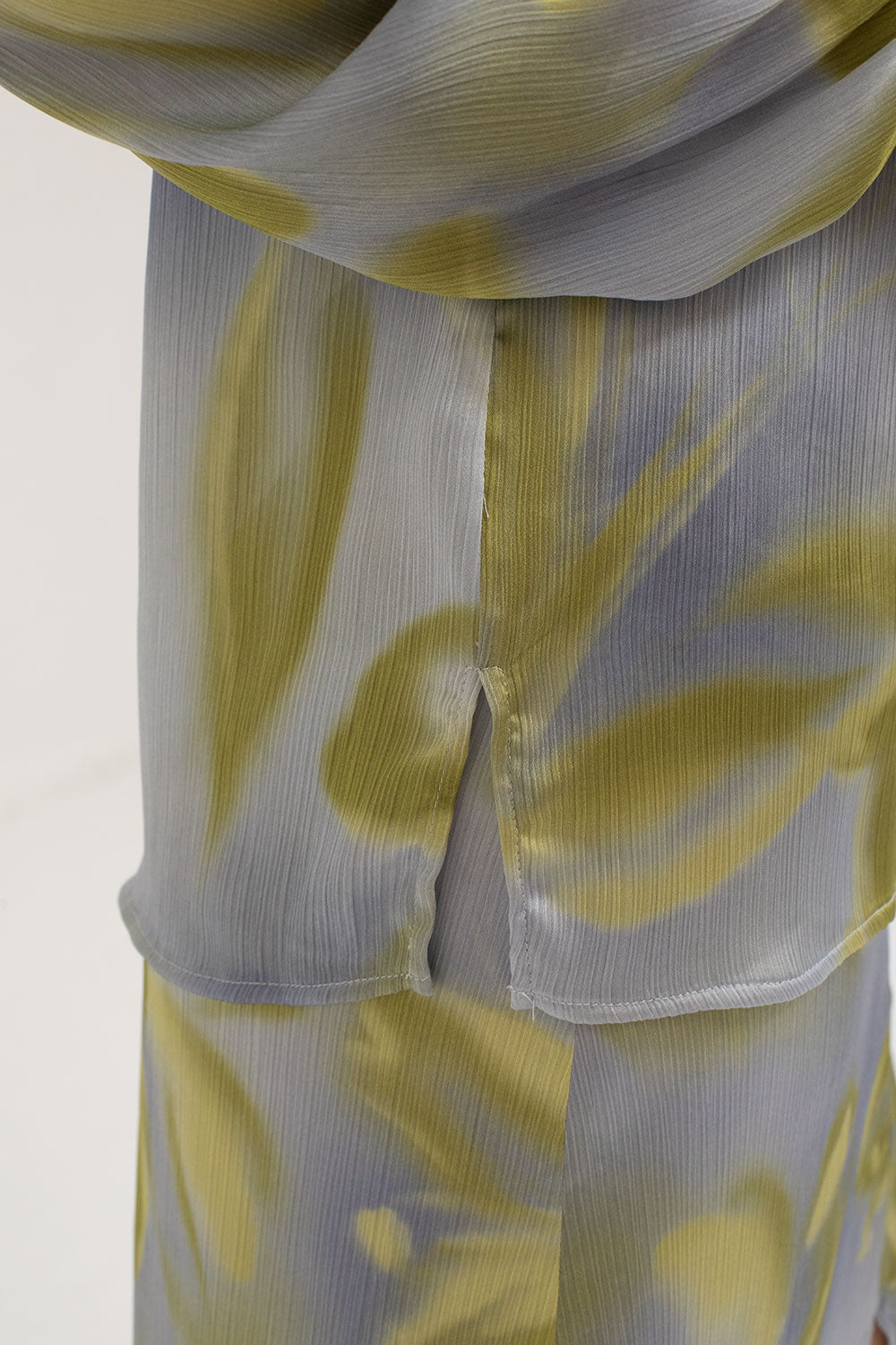 Close up of split detail on side of printed blouse.