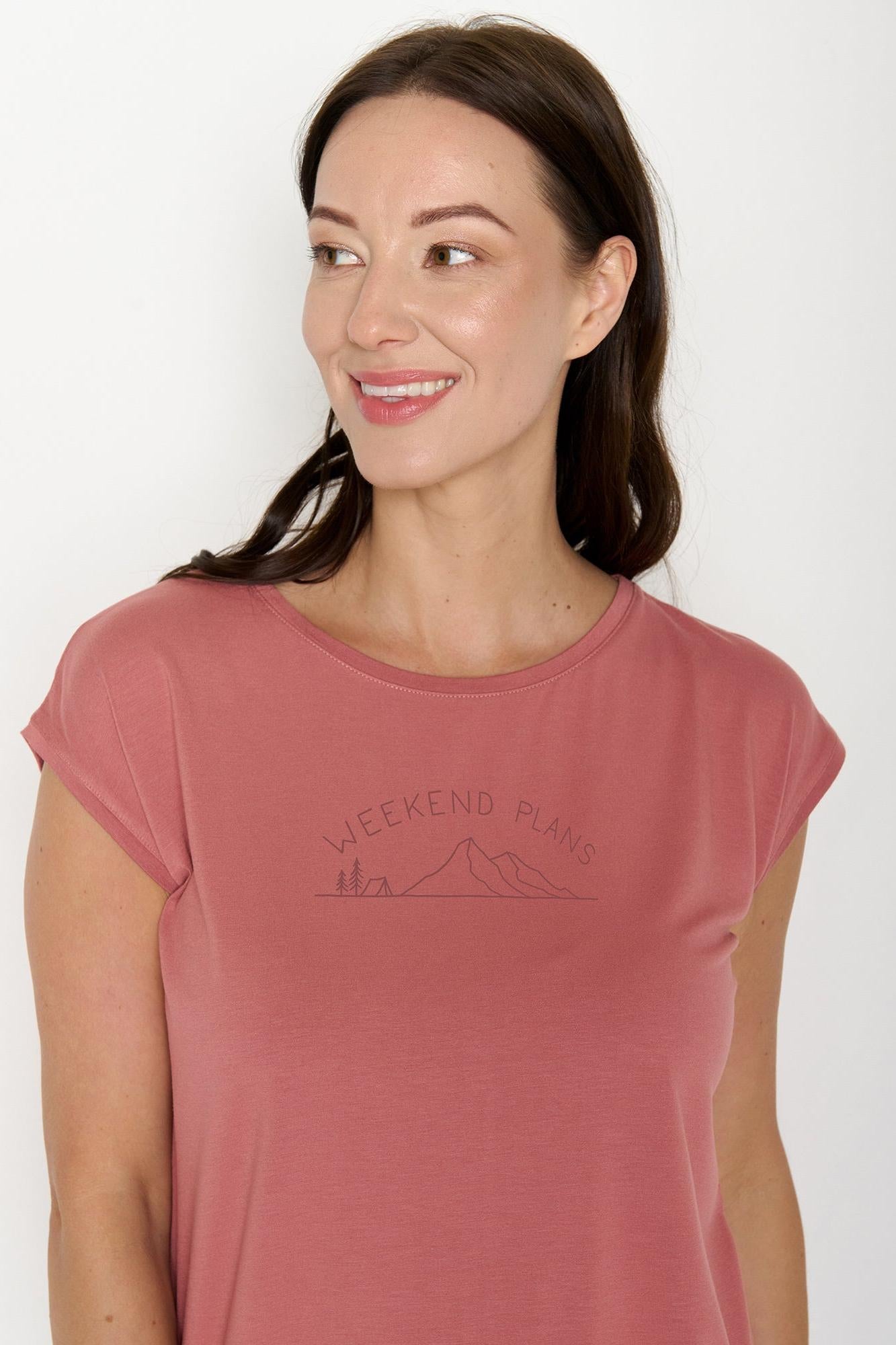 Woman wearing a pink t-shirt with 'Weekend Plans' text on a white background