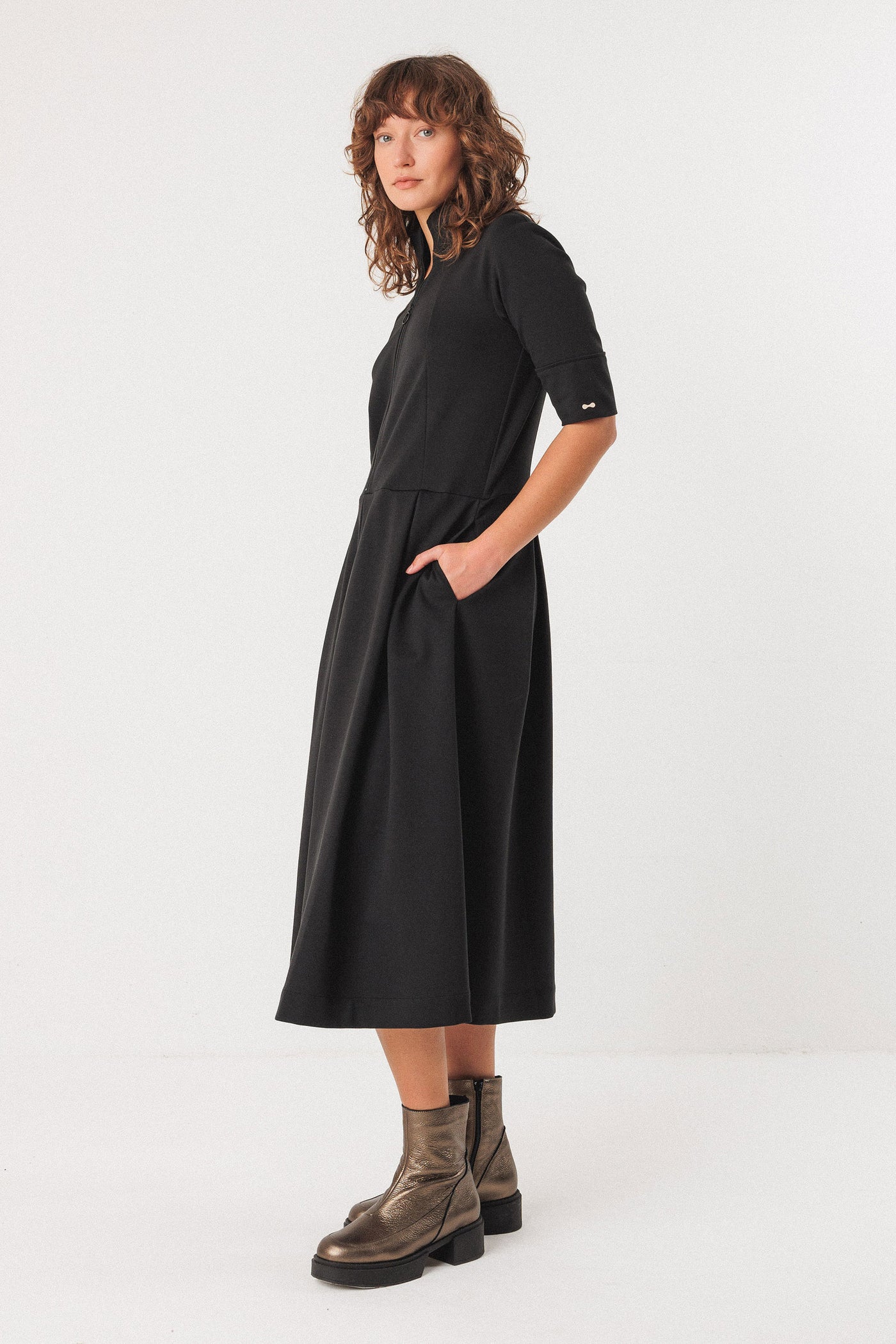 Woman wearing a black dress with short sleeves on a white background