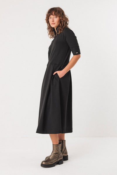 Woman wearing a black dress with short sleeves on a white background