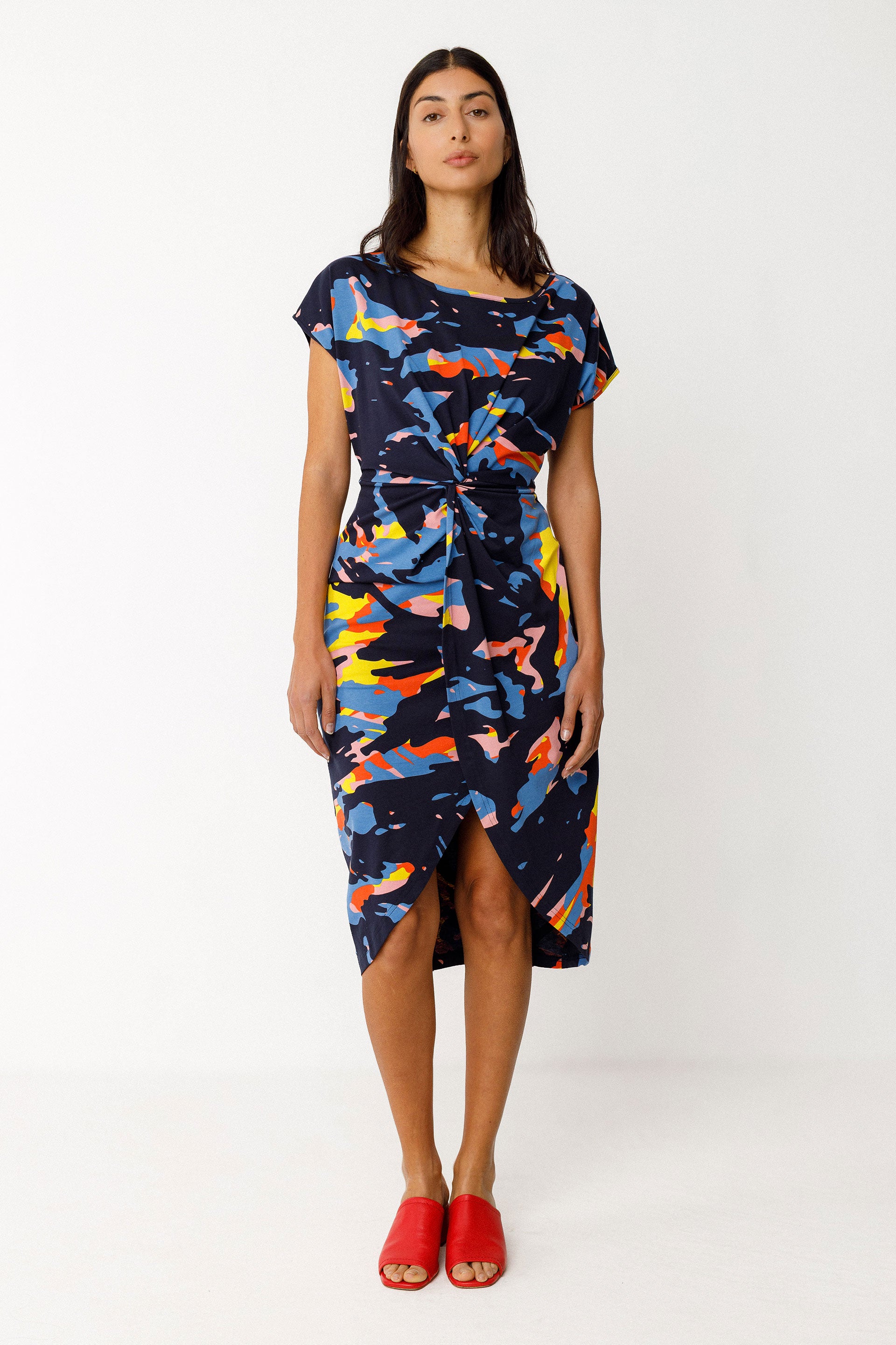 Woman wearing a colorful organic cotton dress with a white background