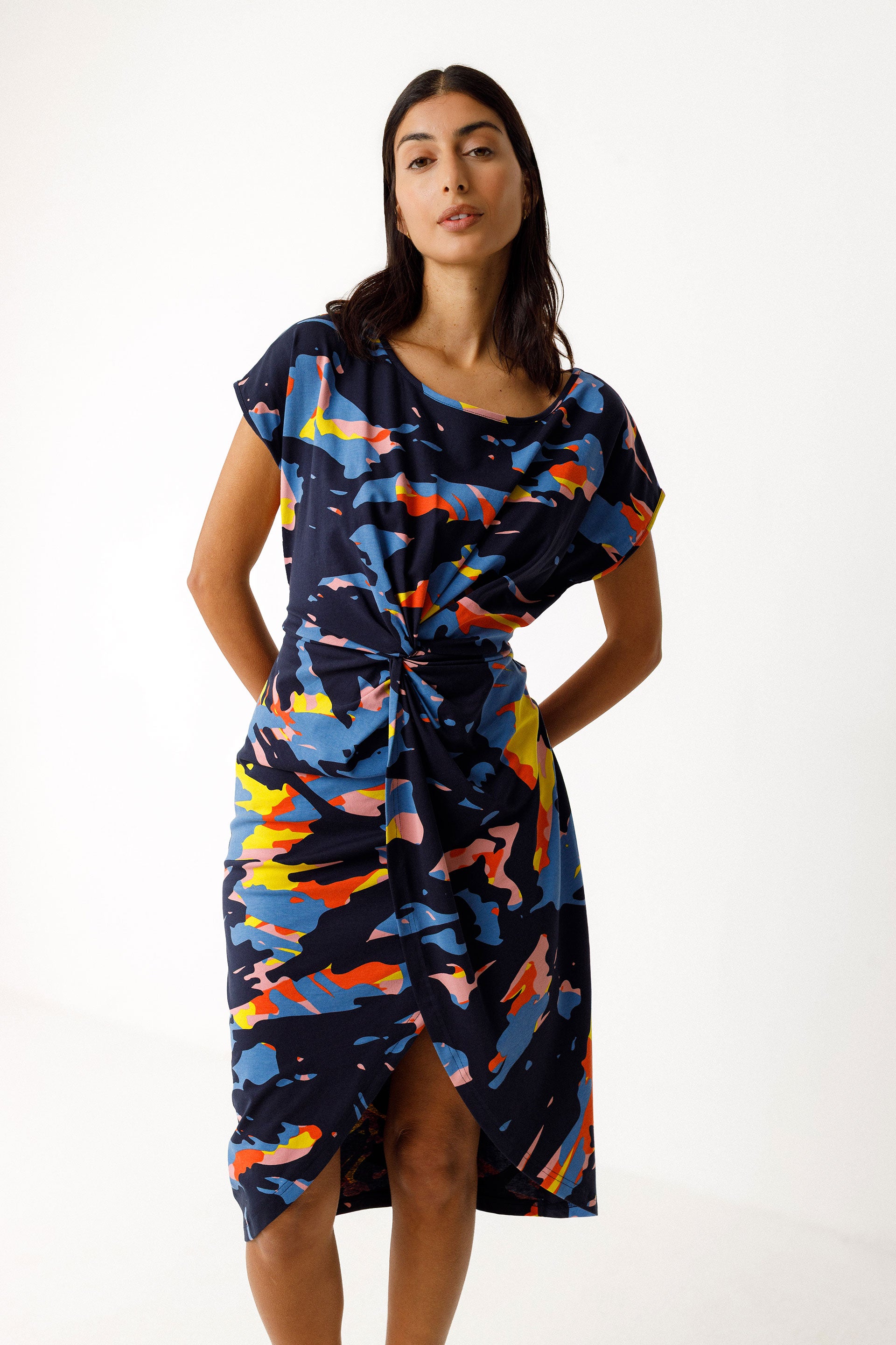 Model wearing colourful organic cotton dress with knotted detail