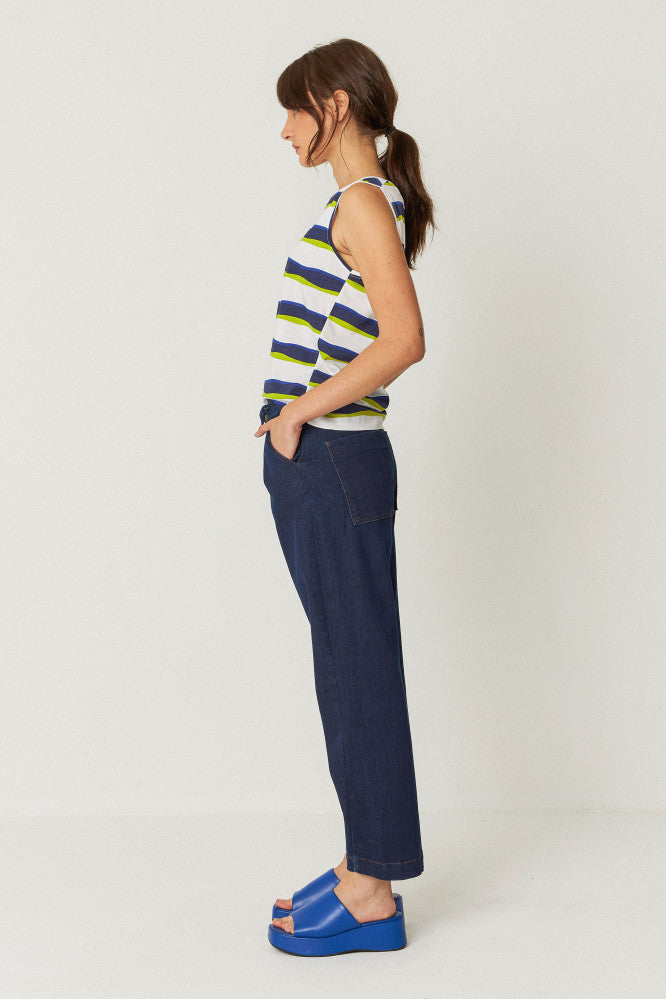 model wearing relaxed fit trousers with an ankle length, side pockets, and a front zip closure side view.