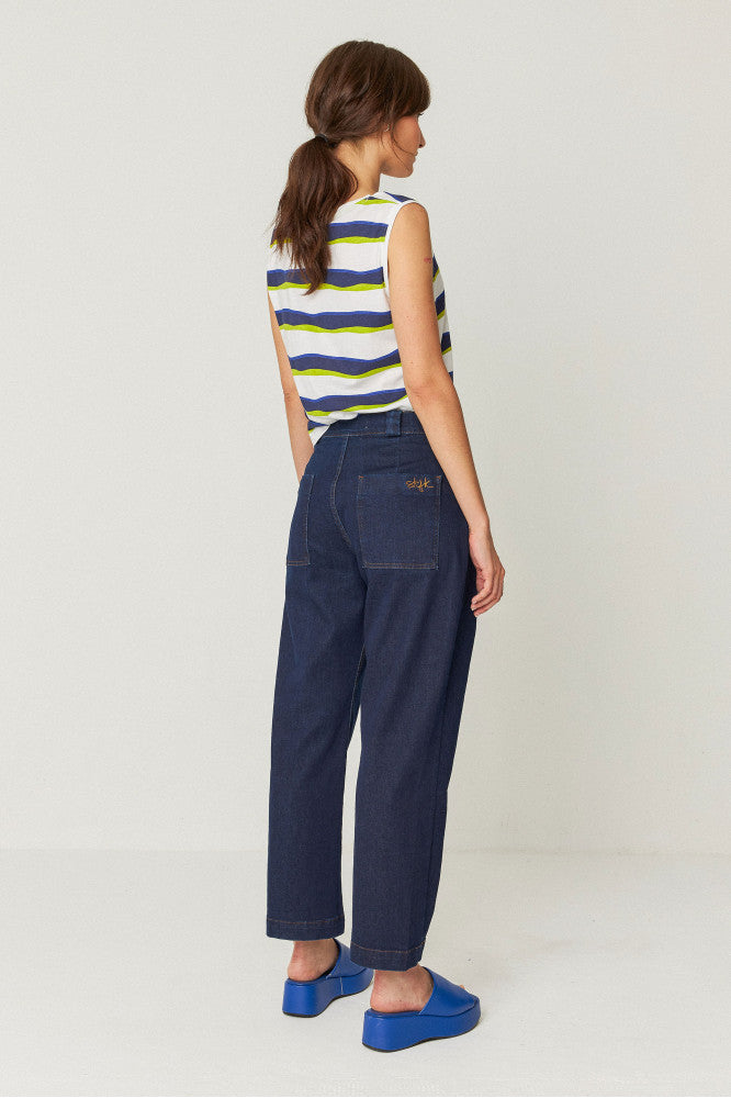 model wearing relaxed fit trousers with an ankle length, side pockets, and a front zip closure back view.