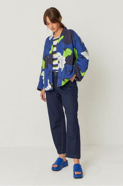 model wearing relaxed fit trousers with an ankle length, side pockets, and a front zip closure and a floral shirt