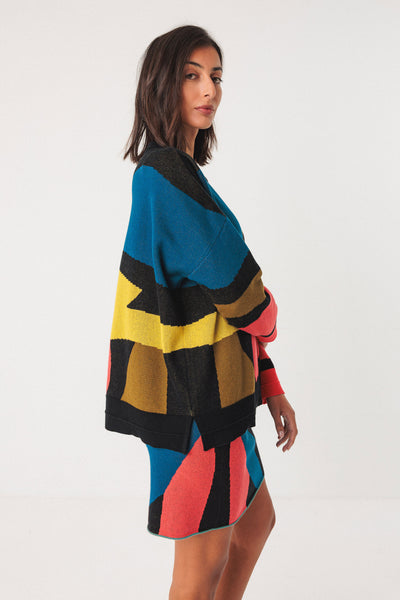 Woman wearing colourful organic cotton skirt with organic knit sweater on white background