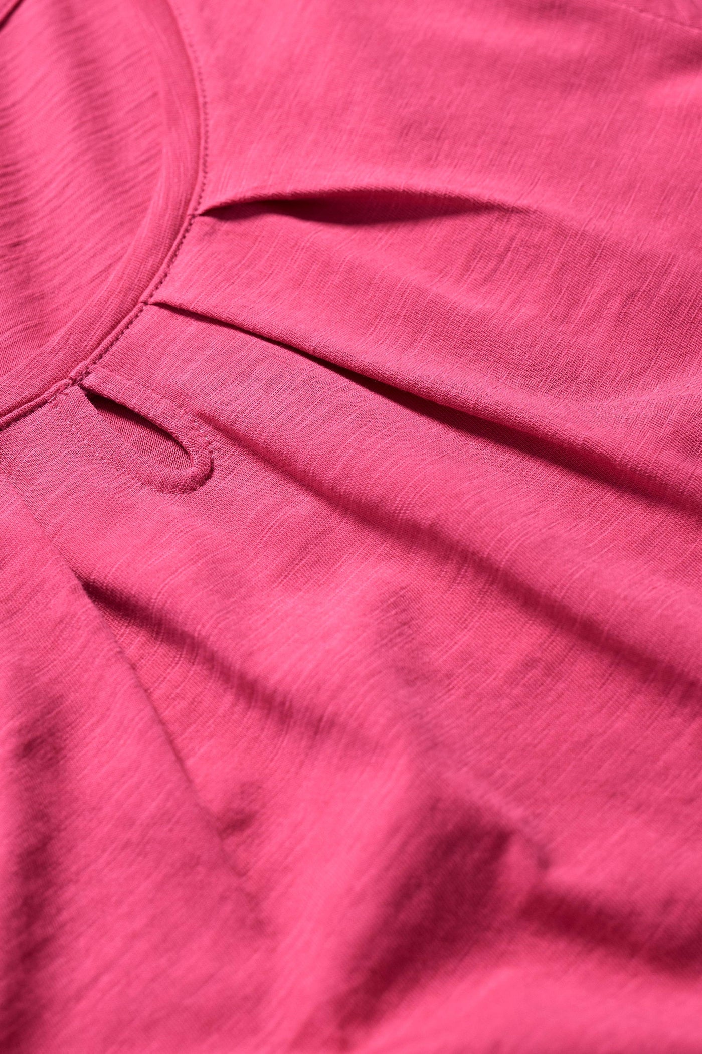 Close-up of the T-shirt’s organic cotton fabric showing a keyhole detail.