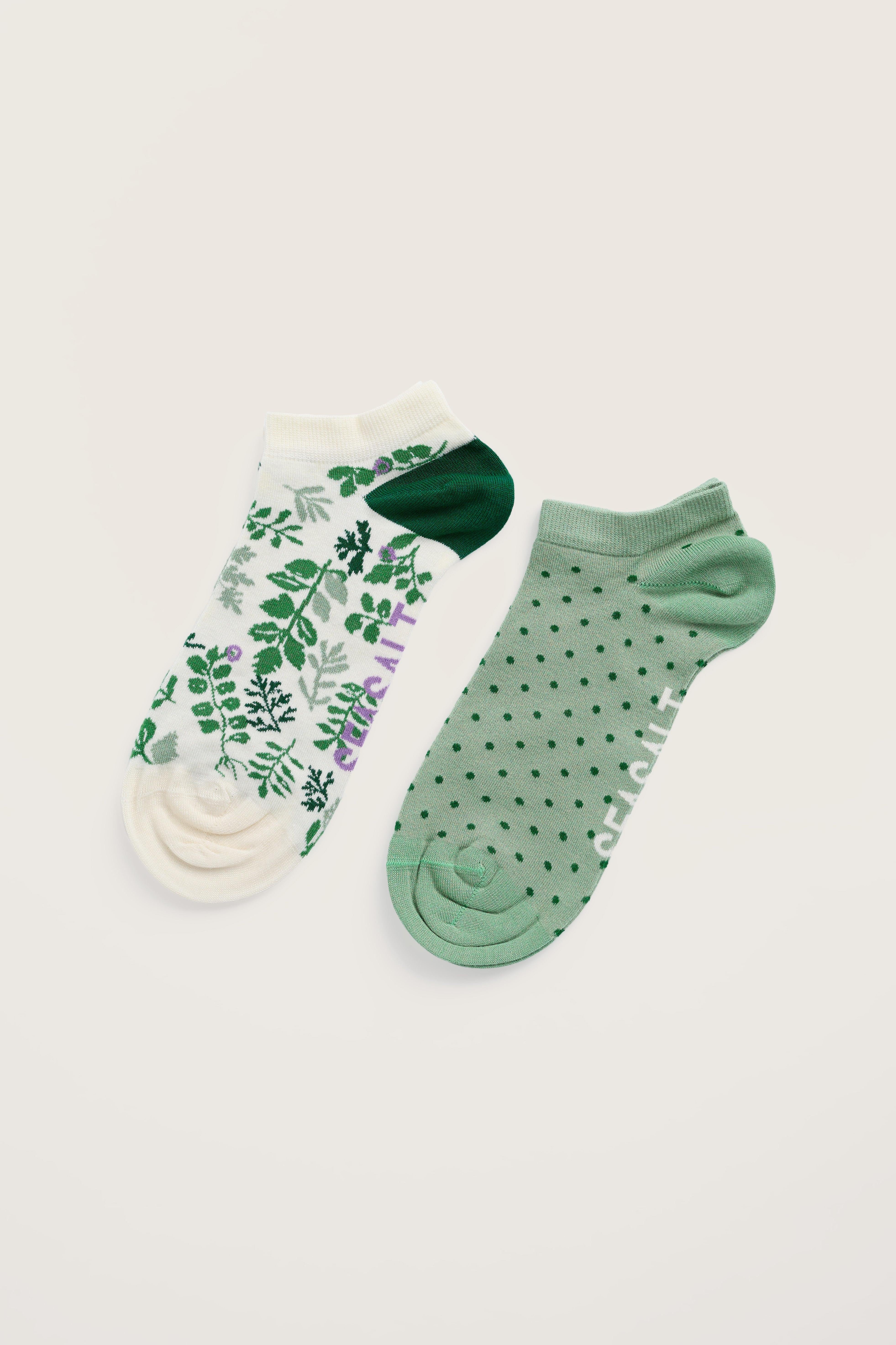 Two pairs of bamboo socks with floral and polka dot patterns on a beige background