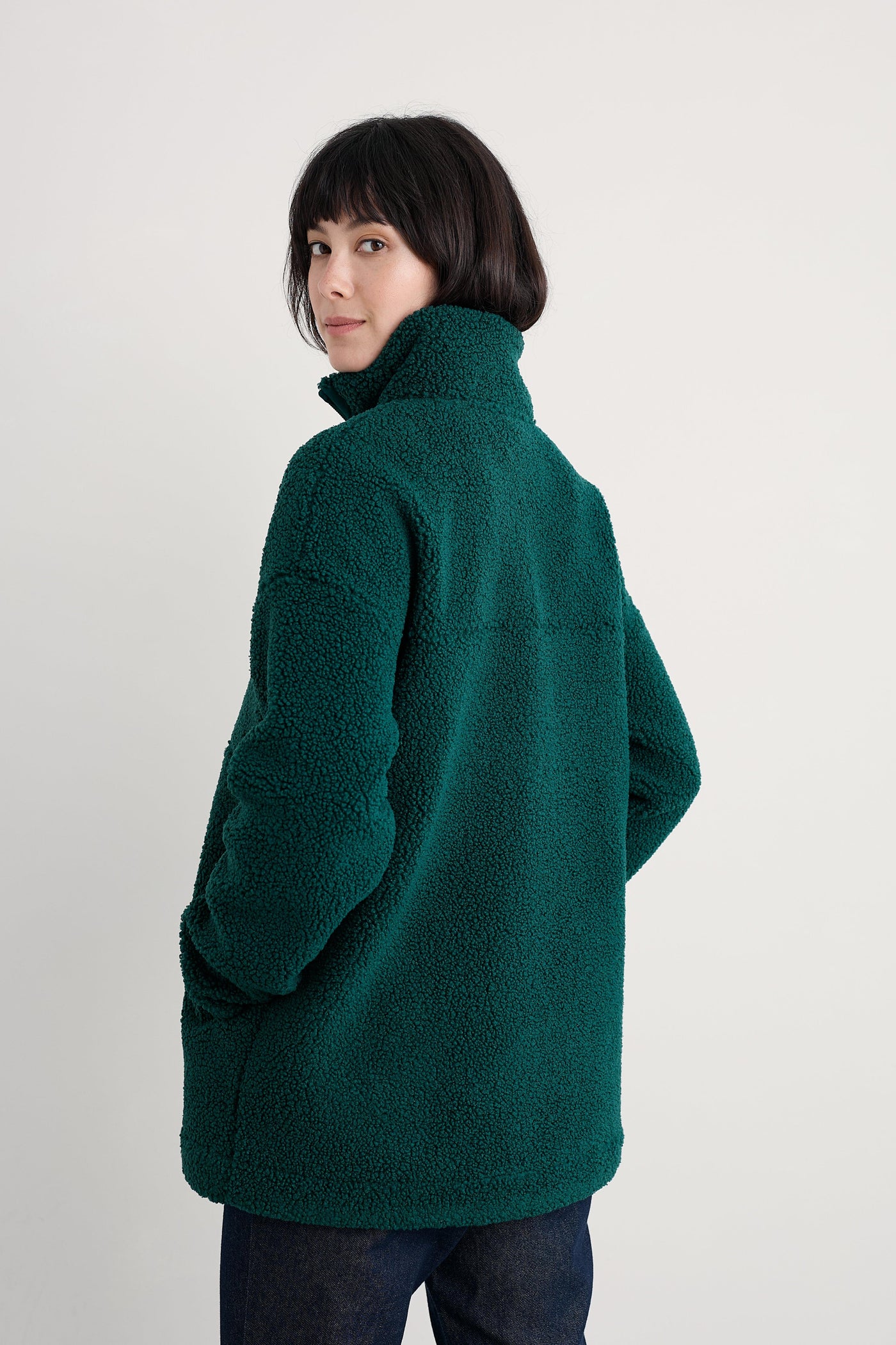Person wearing a green recycled fleece against a white background