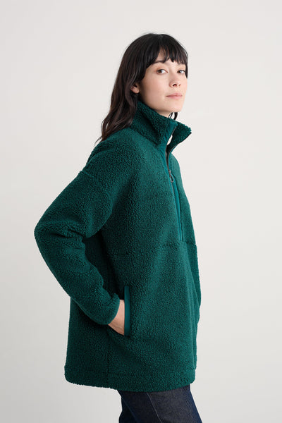 Person wearing a green fleece jacket on a plain background