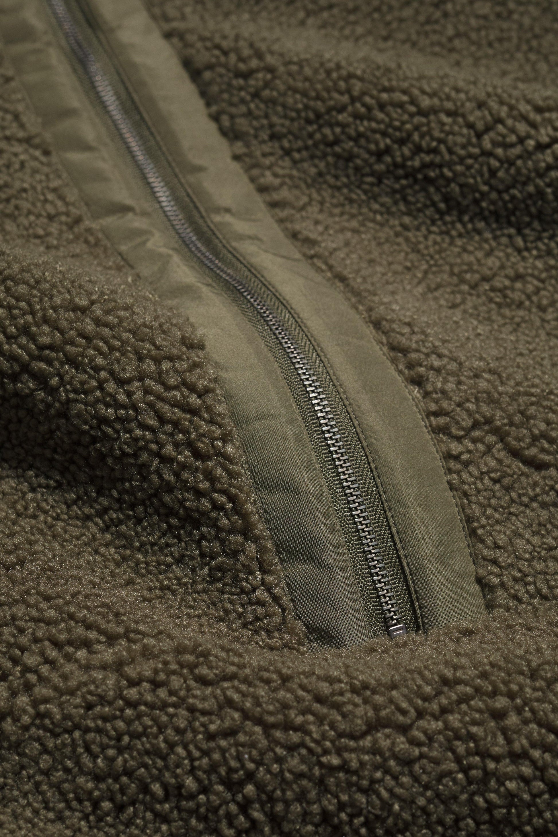 Close-up of a green fleece jacket with a zipper