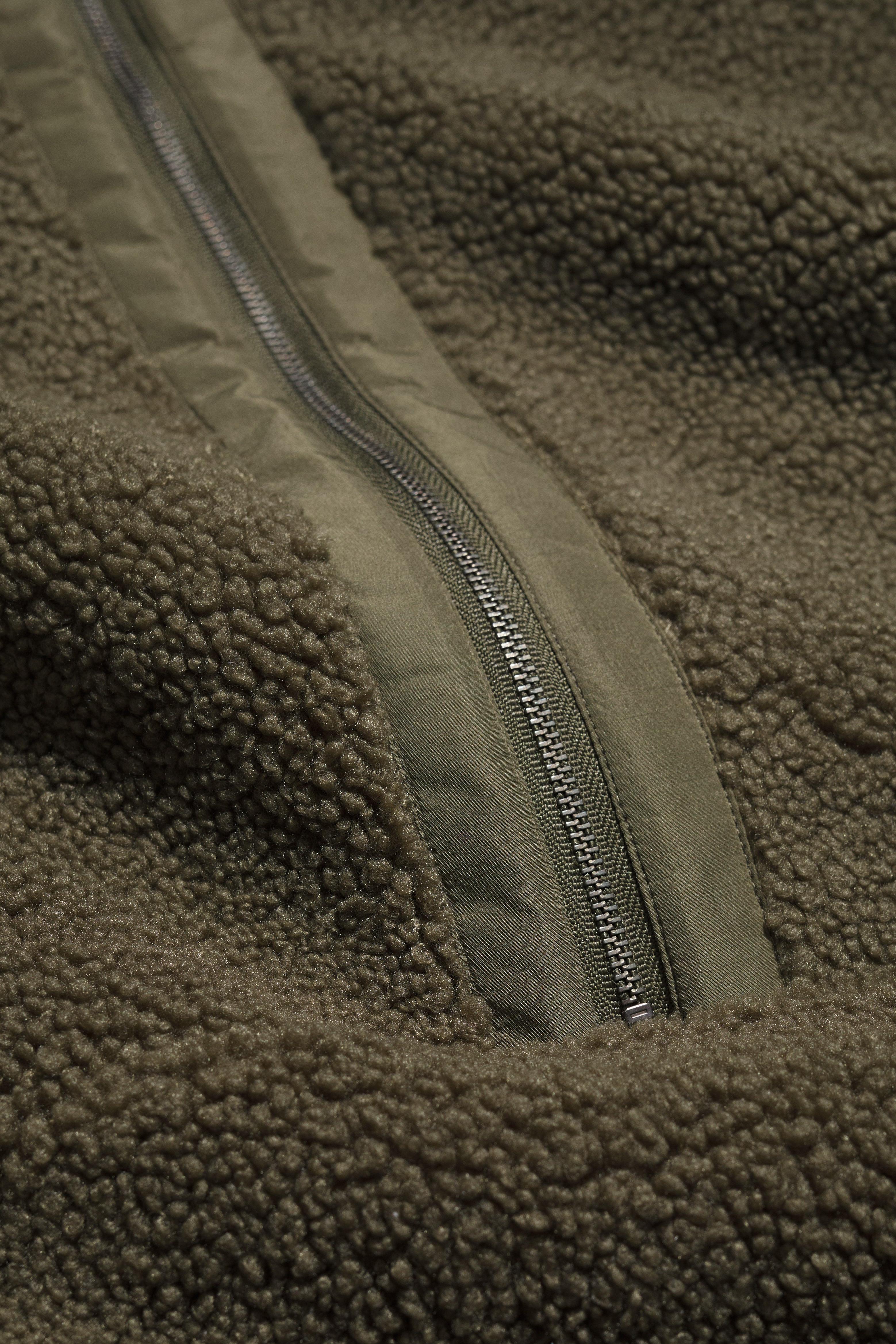 Close-up of a green fleece jacket with a zipper