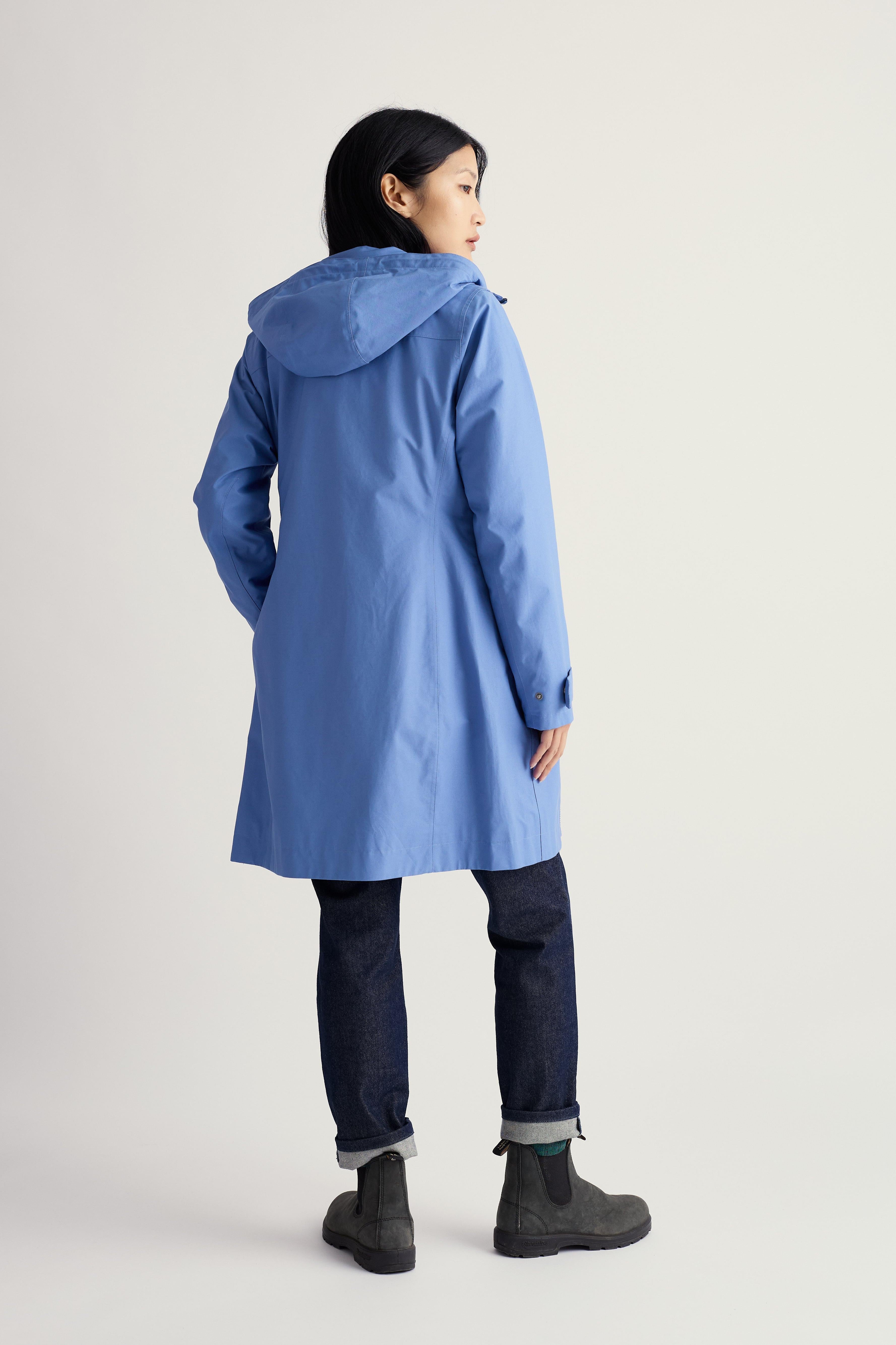 Person wearing a blue raincoat on a light gray background