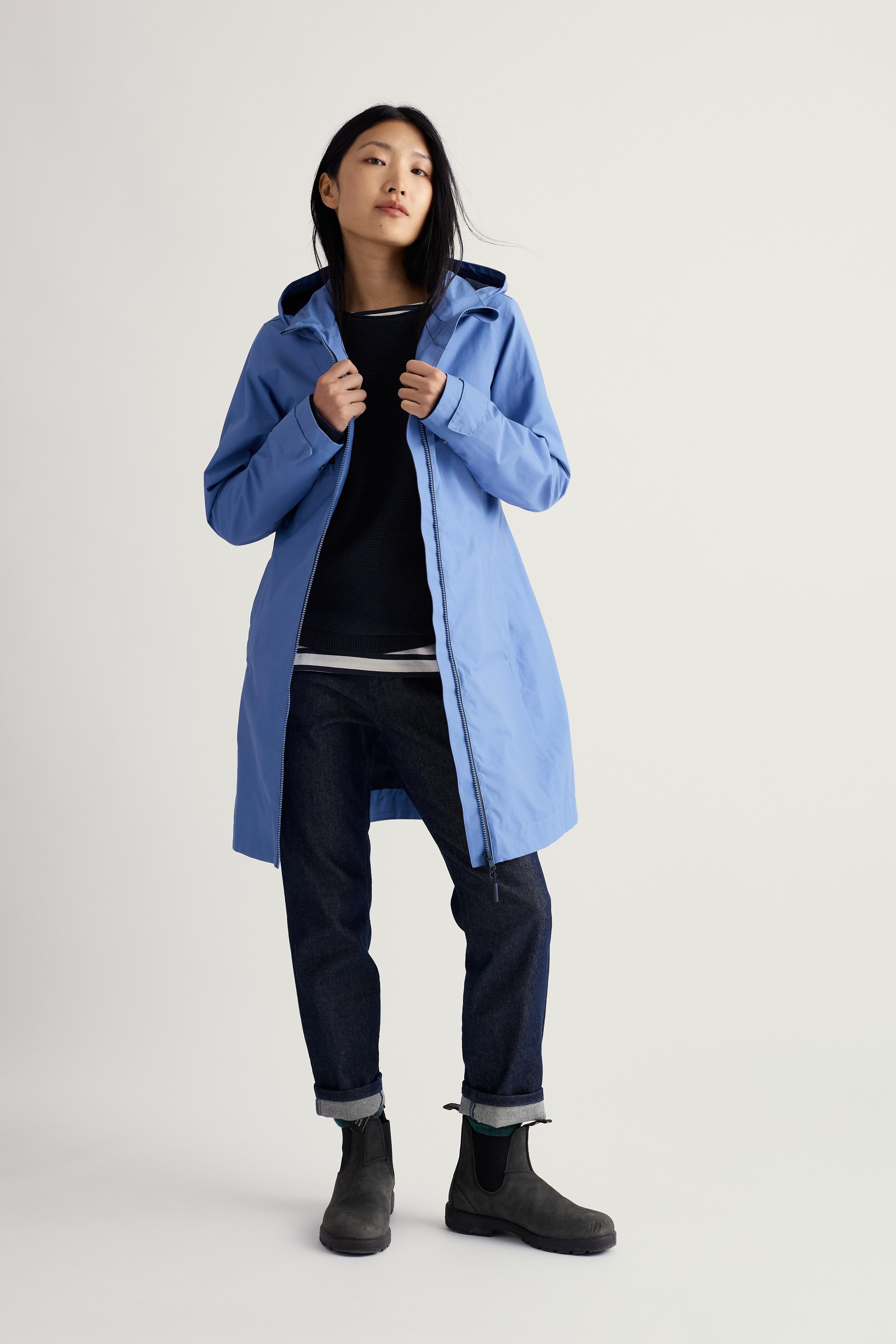 Person wearing a blue coat on a plain background