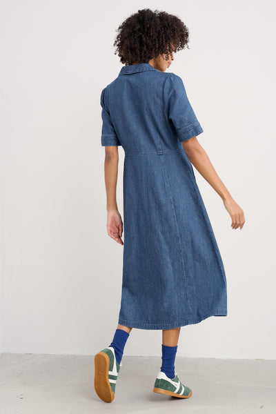 Rear view highlighting the dress's clean lines, the continuation of the waist seam, and the flow of the skirt.