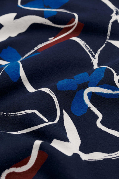 Close-up of fabric with blue, white, and red floral pattern on a dark background