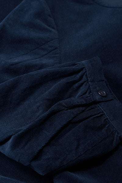 Close-up of a navy blue dress with a button detail