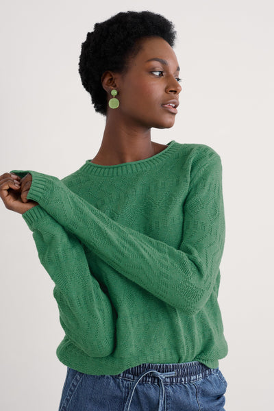 Model wearing the Seasalt Kinter Jumper in Knit Melange Pine, showcasing the crew neckline, long sleeves, and intricate textured stitch patterns.