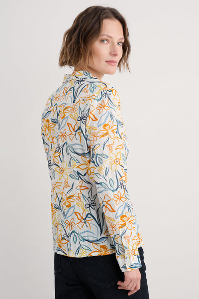 Side profile of the shirt highlighting the relaxed fit, curved hemline, and the vibrant floral print.